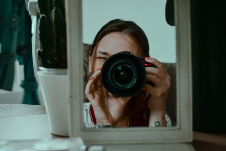Photographer taking a mirror selfie with a DSLR camera — portrait photography tips